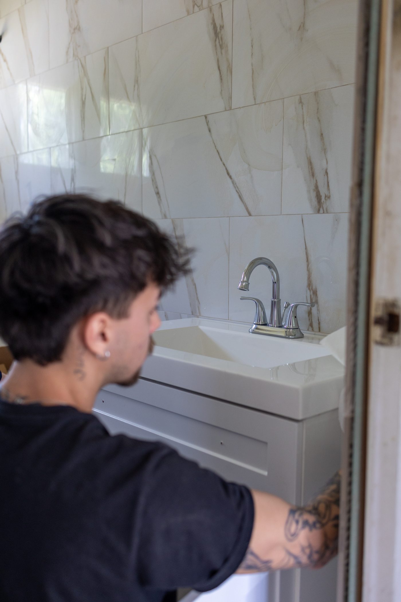 A Hertel plumber fitting a new vanity and faucet